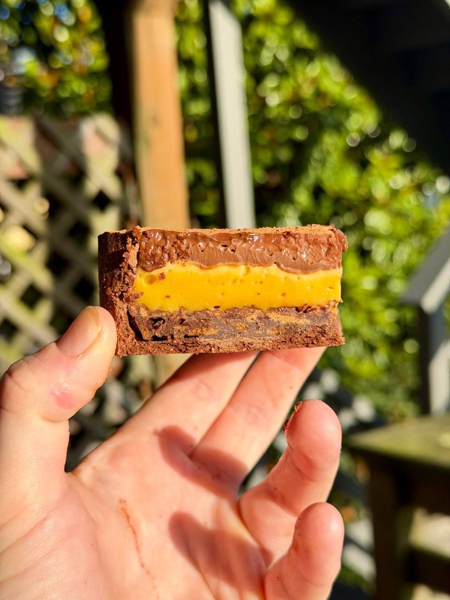 Slice of Chocolate-Passion Tart showing passion fruit curd and chocolate crémeux layers
