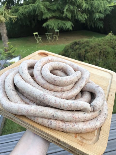 Coiled fresh pork-pistachio sausages on a wooden board