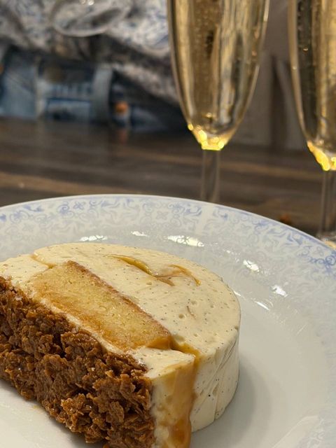 Slice of vanilla, caramel and praliné bûche served with champagne