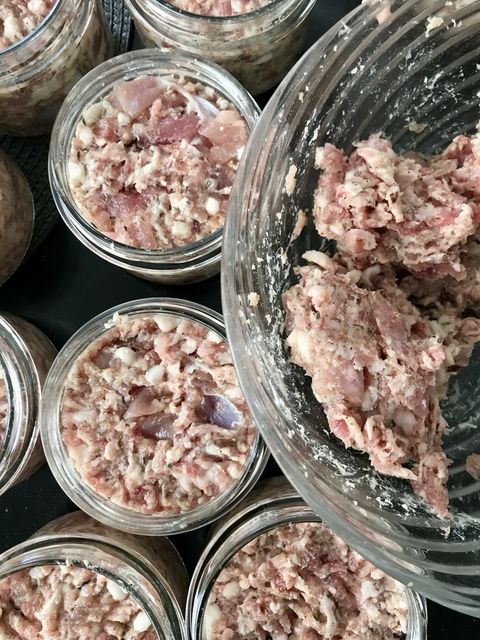 Pale pork mêlée packed into glass jars, with more in a mixing bowl alongside