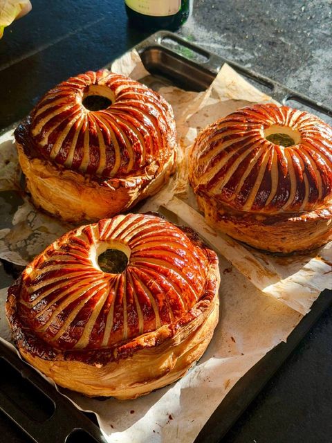 Three baked game pithiviers with deeply golden puff pastry and decorative scoring